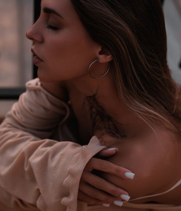 Young woman looking into the distance with peaceful expression in soft lighting.